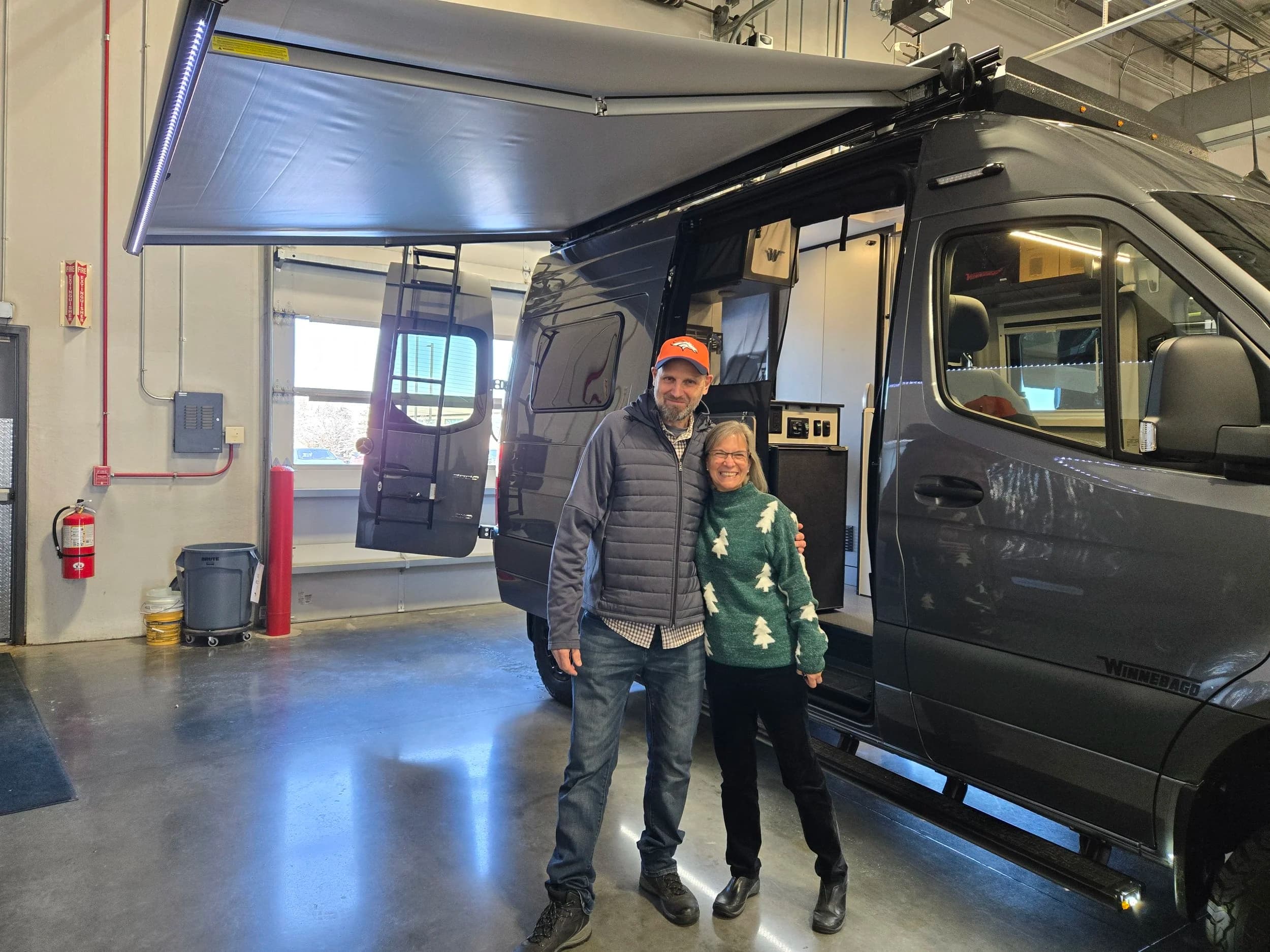 Previous sweepstakes winner standing beside the camper van prize.